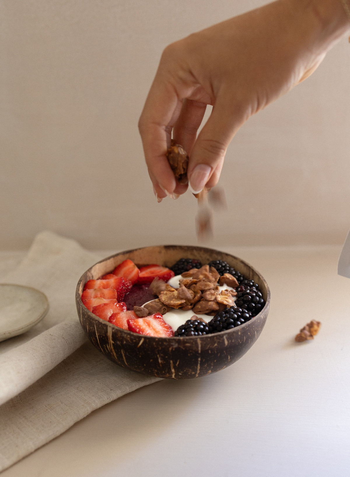 Mano sirviendo chocolates True sobre un bowl con fruta